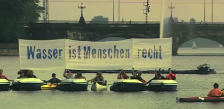Protestaktion: Aneinander gekoppelte Boote mit Transparent: »Wasser ist Menschenrecht«.